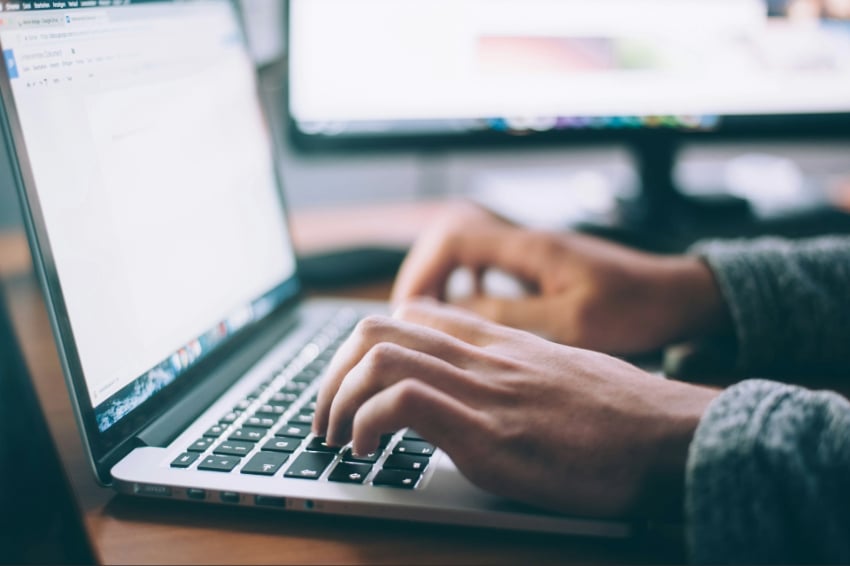 Person types on a laptop