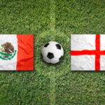 England and Mexico flags on a soccer field with a soccer ball