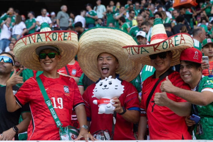 Korean fans wear sombreros reading 
