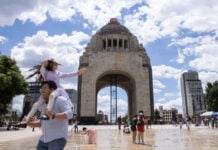 Families play in the fountains of Mexico City's Monument to the Revolution on a warm day.