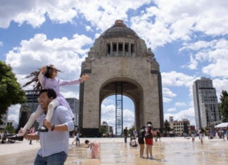 Families play in the fountains of Mexico City's Monument to the Revolution on a warm day.