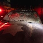 Damaged police car with shattered windshield and dust in Mexico.