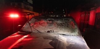 Damaged police car with shattered windshield and dust in Mexico.