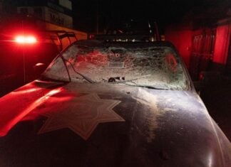Damaged police car with shattered windshield and dust in Mexico.