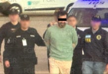 Ex-Navy rear admiral Fernando Farías, handcuffed, accompanied by five federal agents