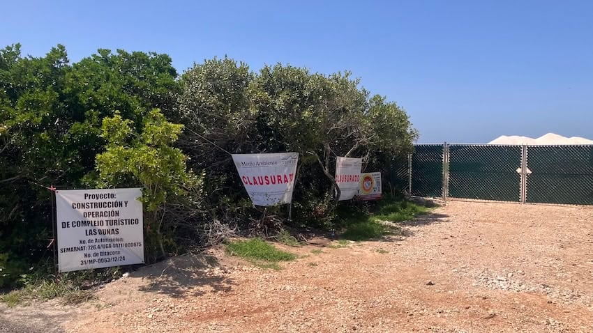 Signs outside the luxury Las Dunas real estate project explain that the project is closed and on hold.