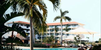 View of pool, hotel and palm trees at an all-inclusive resort in Cancún