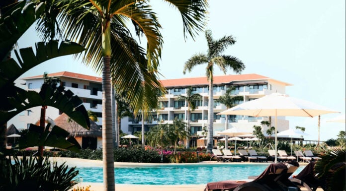 View of pool, hotel and palm trees at an all-inclusive resort in Cancún