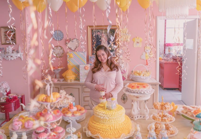 a pregant woman holding her stomach in a very pink room