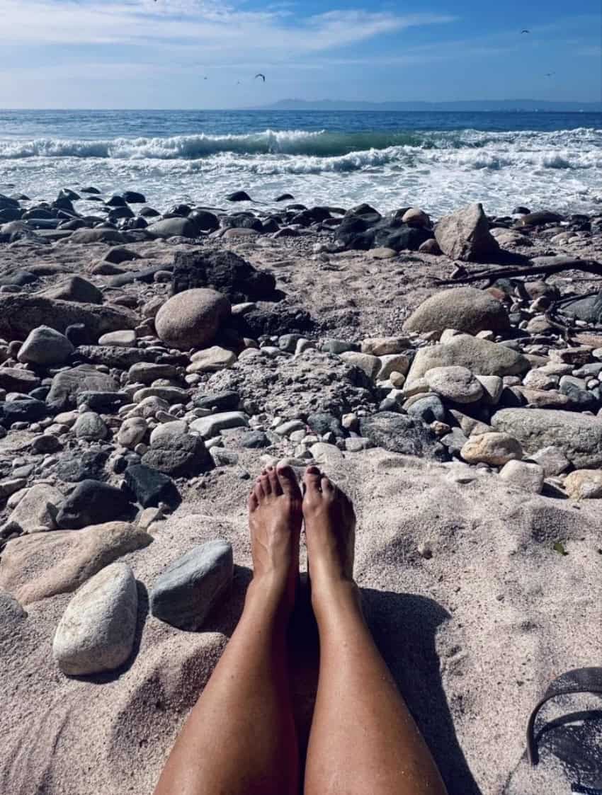 The author on a beach in Jalisco with rocks and Pacific Ocean waves in the foreground