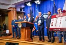 US officials with a poster displaying the CJNG leaders and associated rewards for their capture