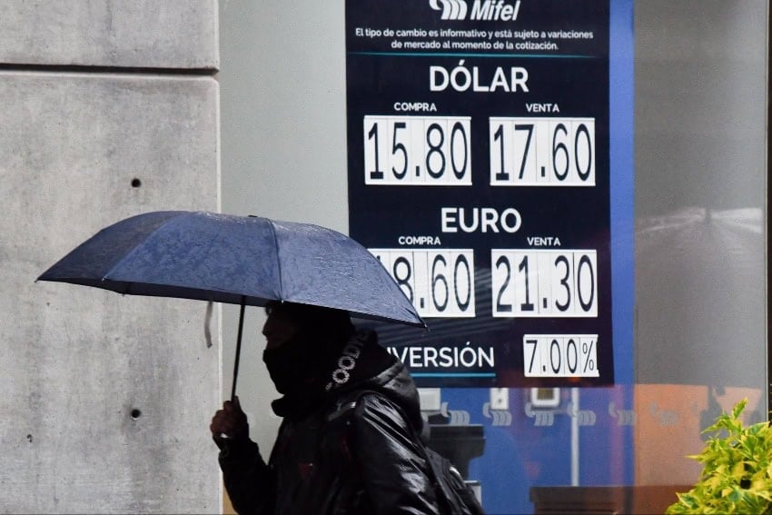 A man walkign in front of a sign with exchange rate.