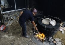 Oaxacan potter stokes the fire for pottery-making in Santa María Atzompa.