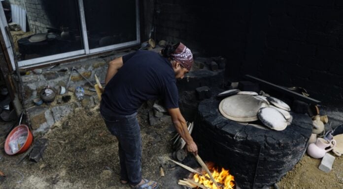 Oaxacan potter stokes the fire for pottery-making in Santa María Atzompa.