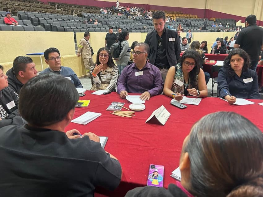 Participants seated around a table at a recycling conference in Mexico City.
