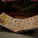 The yellowed pages of the Azcatitlan Codex, showing illustrations of Indigenous people in a line under a pyramid and columns bearing a variety of symbols