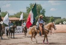 Cow sorting event in San Miguel de Allende, with woman on horseback waving the Mexican flag