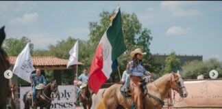 Cow sorting event in San Miguel de Allende, with woman on horseback waving the Mexican flag