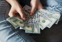 Woman fanning a pile of U.S. 100 dollar bills.