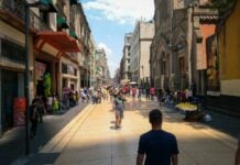 Mexico City, with a man with his back to the camera staring out at a colorful scene