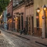 Santiago de Querétaro street scene, with car pulling out from a narrow block filled with residential housing.