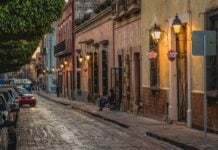 Santiago de Querétaro street scene, with car pulling out from a narrow block filled with residential housing.