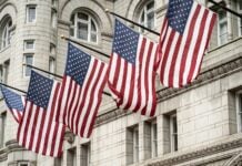 Flags flying in front of a U.S. building