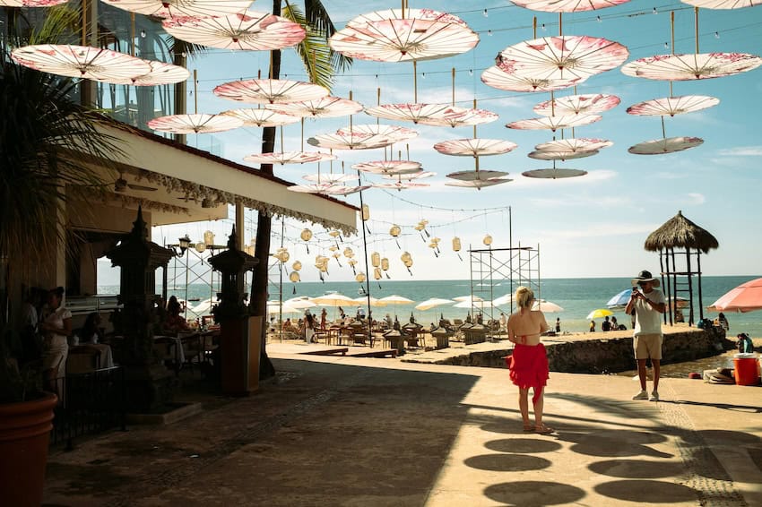 A couple takes a photo next to an outdoor cafe in Puerto Vallarta.