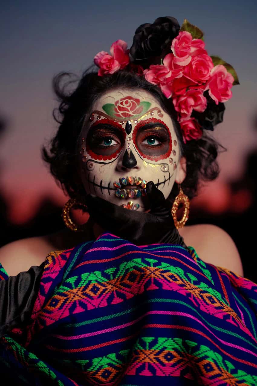Día de Muertos model wearing face paint and flowers in her hair