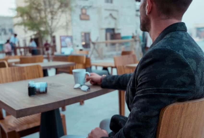 Man sitting at a cafe with a cup of coffee