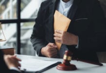 An official pockets a money envelope - stock photo showing corruption