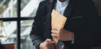 An official pockets a money envelope - stock photo showing corruption