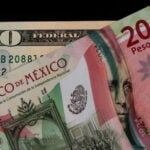 A 20-Mexican peso bill and a 20-US dollar bill