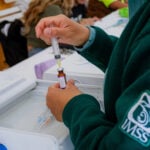 A nurse wearing an IMSS uniform draws a vaccine