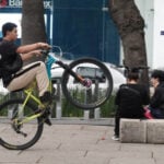 A young man on a bicycle pops a wheelie as he rides down Paseo de La Reforma in Mexico City.