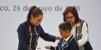 President Sheinbaum presents a scholarship card to a young boy
