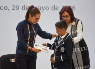 President Sheinbaum presents a scholarship card to a young boy