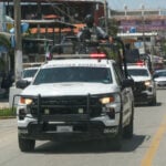National Guard vehicles drive in a line through and urban area during a September operation in Coyuca de Benítez, Guerrero.