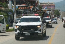 National Guard vehicles drive in a line through and urban area during a September operation in Coyuca de Benítez, Guerrero.