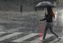 woman walking with an umbrella through heavy rain