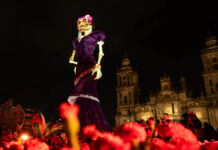 A 33-meter Catrina figure towers over the Metropolitan Cathedral at night in Mexico City's Zócalo square