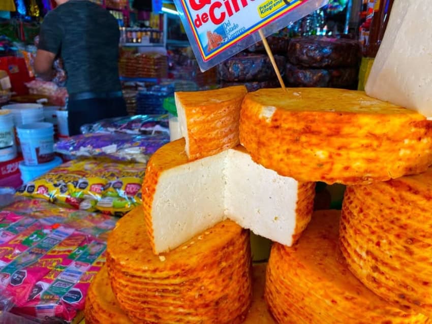 queso de cincho wheels stacked up at a Tijuana market