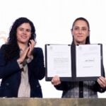 President Sheinbaum held up the dual nationality decree after signing it, alongside her legal counsel, Luisa María Alcalde.