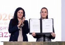 President Sheinbaum held up the dual nationality decree after signing it, alongside her legal counsel, Luisa María Alcalde.