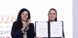 President Sheinbaum held up the dual nationality decree after signing it, alongside her legal counsel, Luisa María Alcalde.
