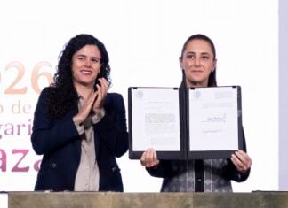 President Sheinbaum held up the dual nationality decree after signing it, alongside her legal counsel, Luisa María Alcalde.