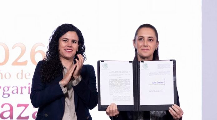 President Sheinbaum held up the dual nationality decree after signing it, alongside her legal counsel, Luisa María Alcalde.