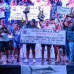 Winning team at Bisbee's Black and Blue 2026 fishing tournament in Los Cabos holding up trophies and check.