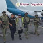 Mexican authorities escort accused fuel smuggler and former Navy officer Miguel Ángel Solano Ruiz, aka "Capitán Sol," onto a plane in handcuffs