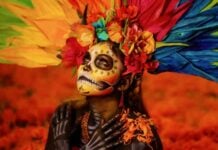 A portrait of a Catrina surrounded by iconic Día de Muertos symbols.